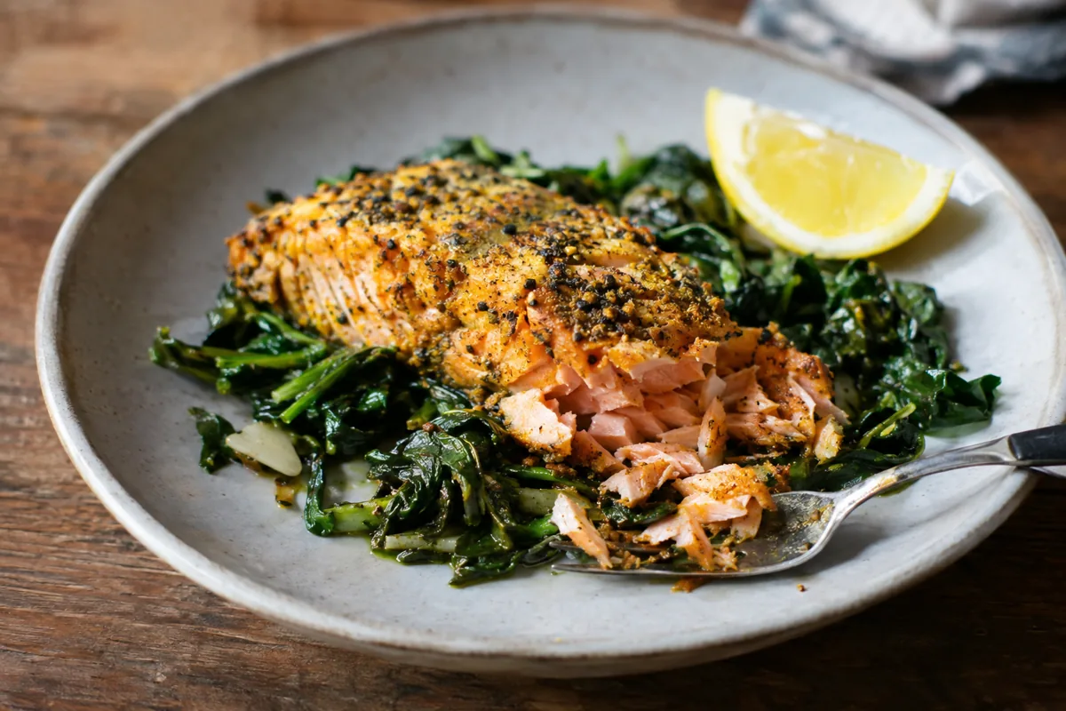 turmeric salmon fillet on garlicky greens with lemon
